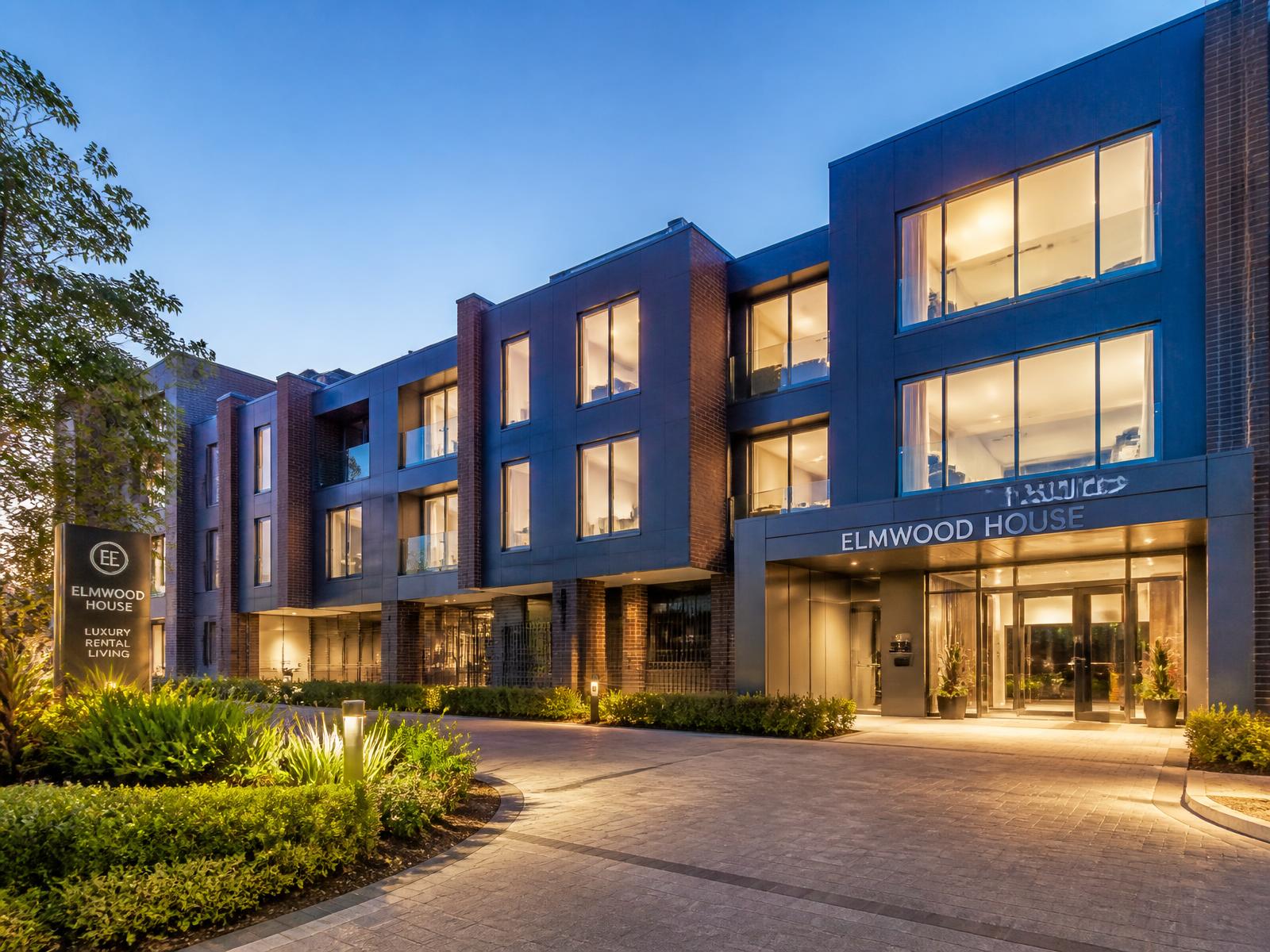 Modern apartment building exterior lit at dusk